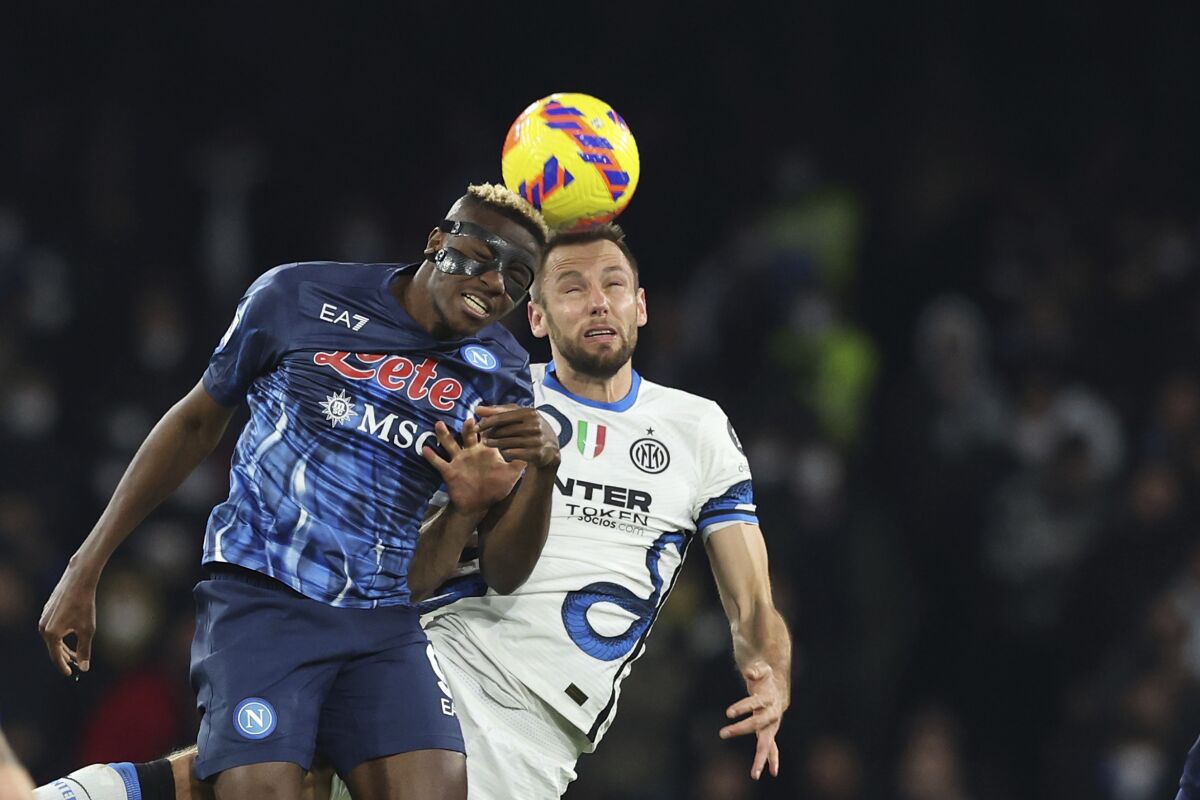 Napoly's Victor Osimhen, left, and Inter's Stefan de Vrij jump for the ball during the Italian Serie A soccer match between Napoli and Inter Milan at the Diego Armando Maradona stadium in Naples, Italy, Saturday, Feb. 12, 2022. (Alessandro Garofalo/LaPresse via AP)