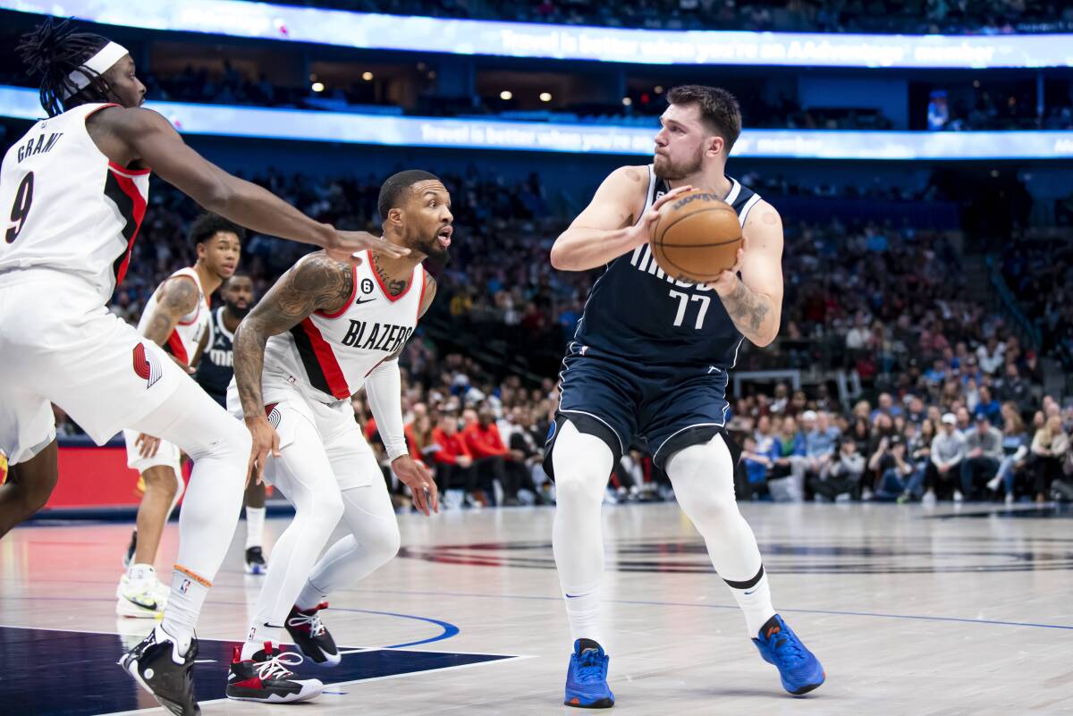 Dallas Mavericks guard Luka Doncic (77) looks to pass the ball as Portland Trail Blazers guard Damian Lillard (0) defends against him in the first half of an NBA basketball game in Dallas, Friday, Dec. 16, 2022. (AP Photo/Emil Lippe)