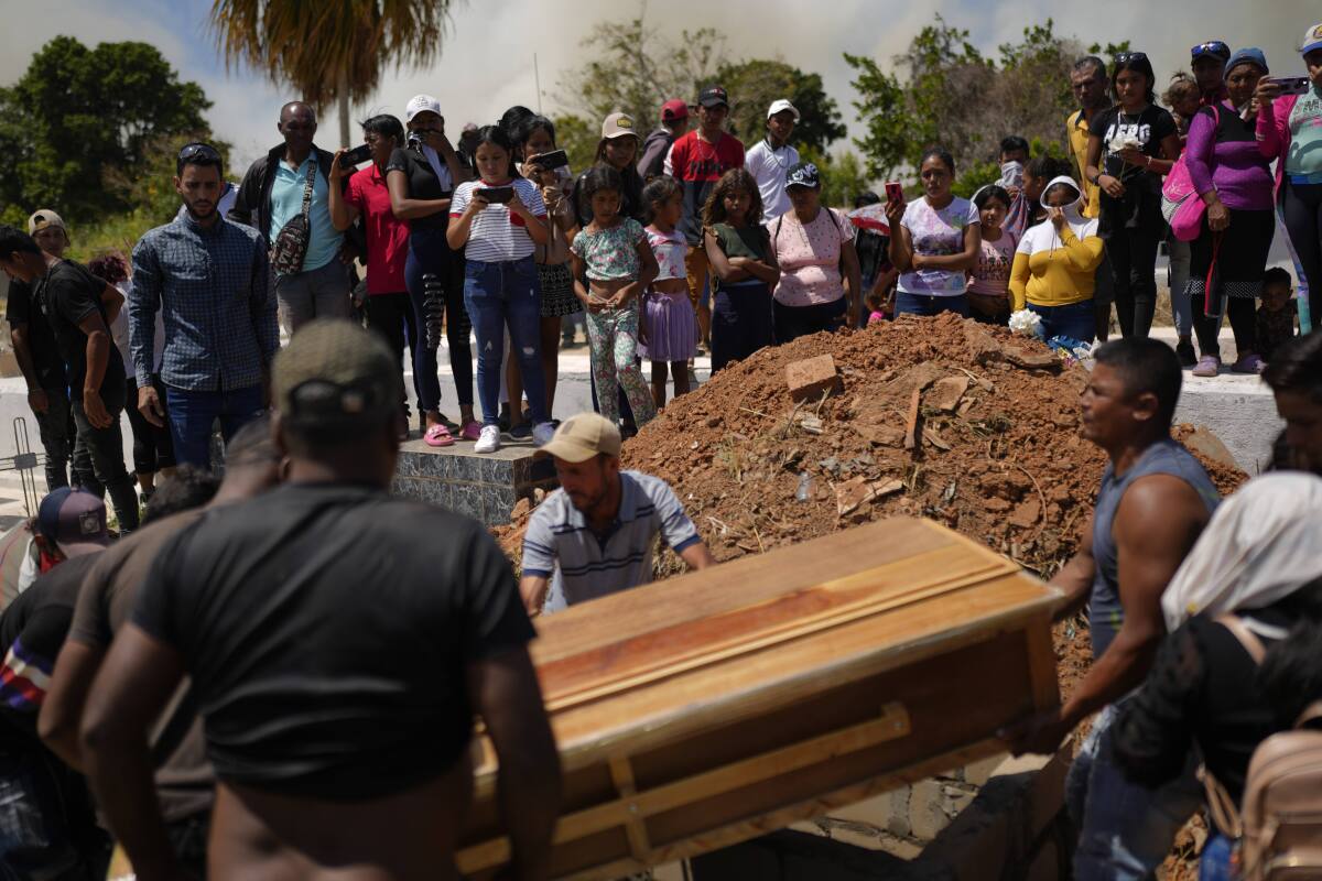 Residentes colaboran para colocar un ataúd con los restos del minero Richard