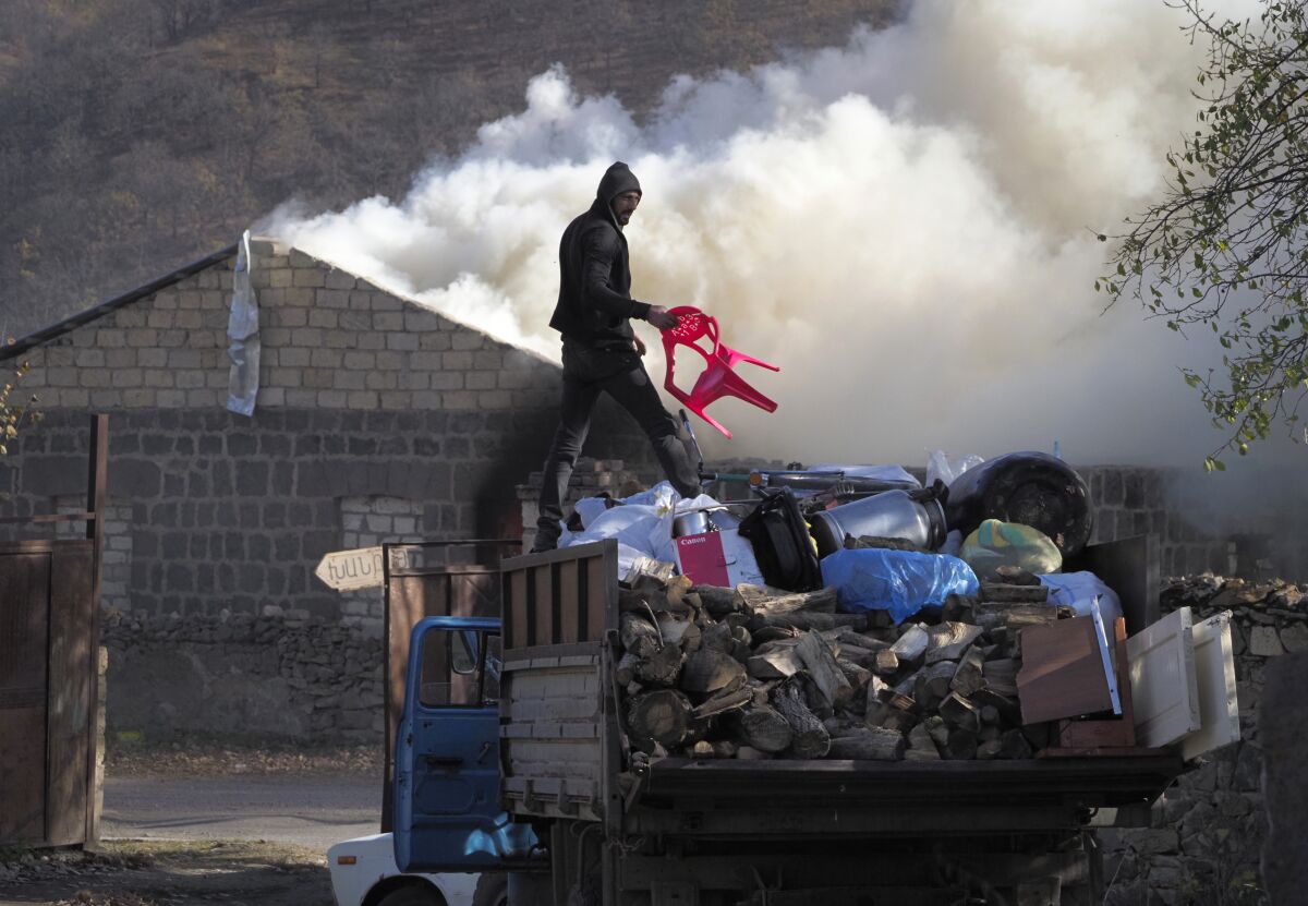 A man loads possessions on his truck after setting his home on fire on Friday in the separatist region of Nagorno-Karabakh.