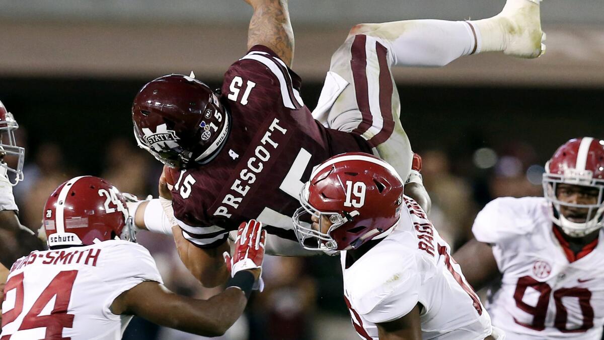 Mississippi State quarterback Dak Prescott is upended by Alabama defenders in the second half Saturday.