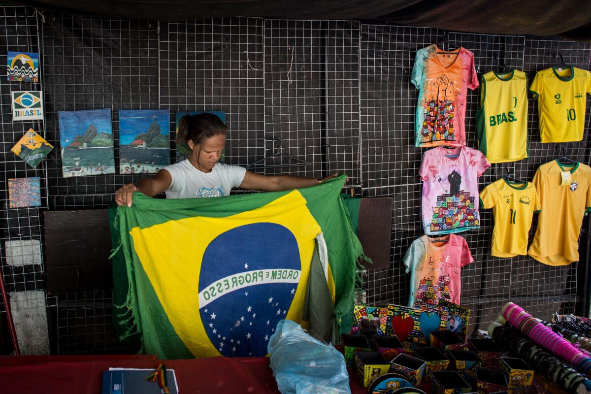 RIO DE JANEIRO, BRAZIL - AUGUST 17: A woman prepares a souvenir stall ahead of the arrival of tour groups at the Rochina 'favela' community on August 17, 2016 in Rio de Janeiro, Brazil. With the Rio 2016 Olympic games currently underway, for many 'favela ' communities tourism has become a source of income in the lead up and during the games. The governments 'pacification' plan has seen some favela communities become safe enough for tour groups to run daily walking and jeep tours. Around 1.4 million residents, or approximately 22 percent of Rio's population, reside in favelas which often lack proper sanitation, health care, education and security due to gang and police violence. (Photo by Chris McGrath/Getty Images) ** OUTS - ELSENT, FPG, CM - OUTS * NM, PH, VA if sourced by CT, LA or MoD **