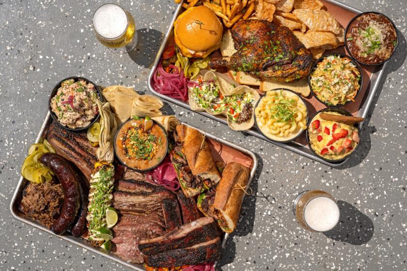 Aluminum platters filled with meats and chicken smoked onsite at Heritage Barbecue & Brewery in Oceanside.