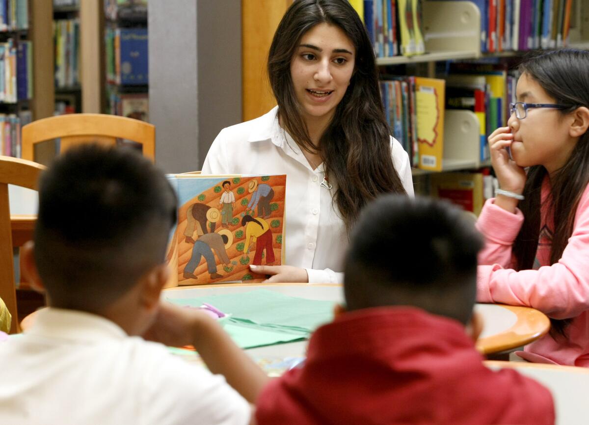 Clark Magnet High School senior Noor Atif read a book about Cesar Chavez to school children at Pacific Park Library in Glendale on Thursday, March 13, 2014. Atif is a voluteer at the library and teaching about Chavez is part of her senior project.