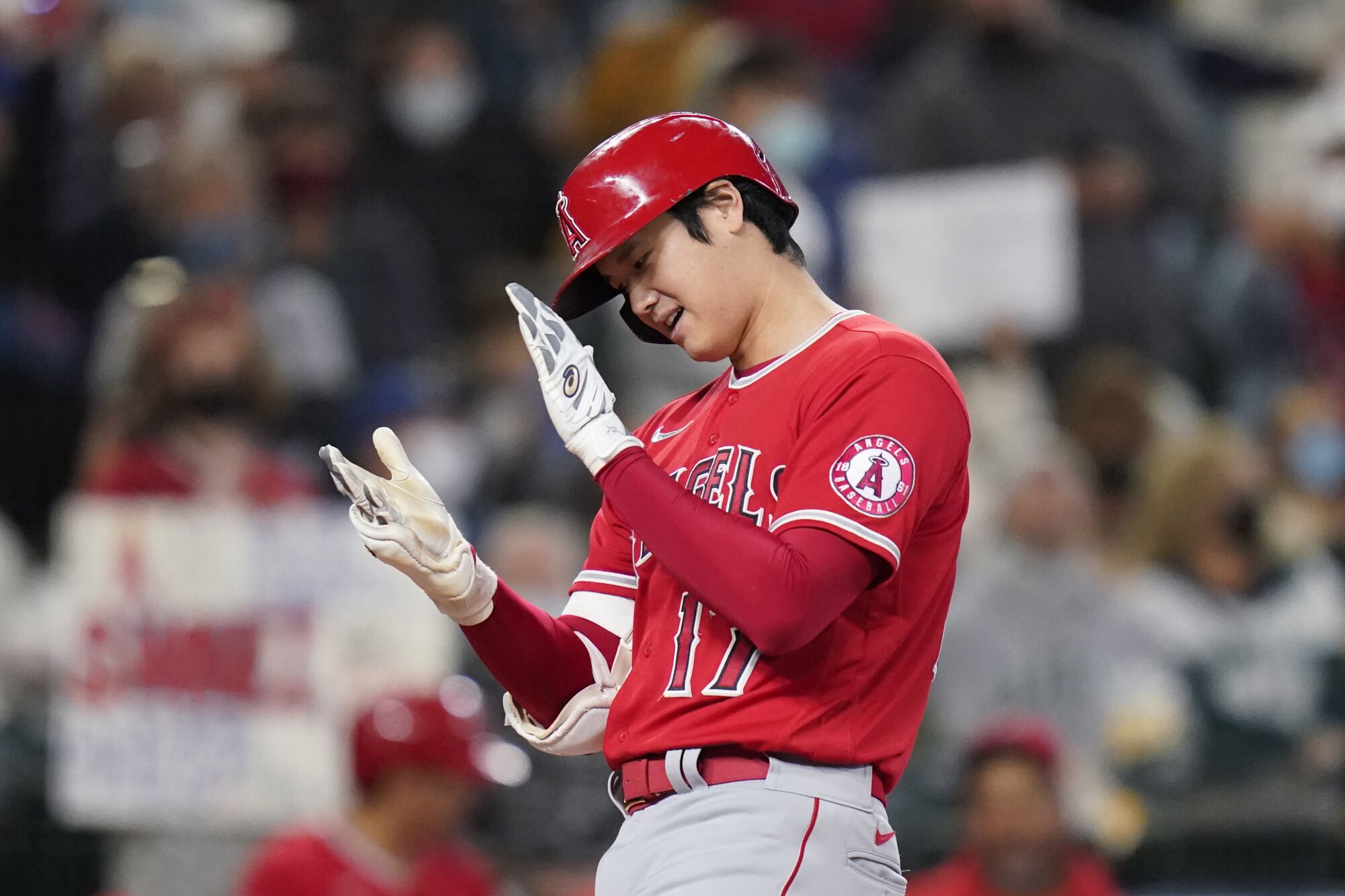 Los Angeles Angels' Shohei Ohtani claps his hands together as he crosses home after a solo home