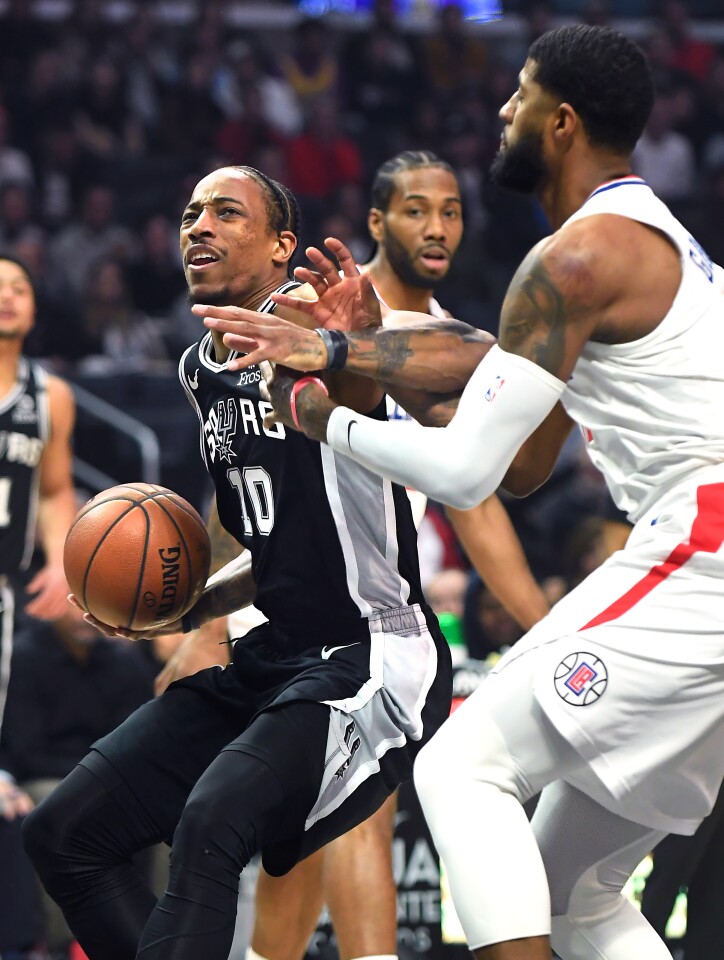 LOS ANGELES, CALIFORNIA FEBUARY 3, 2020-Clippers Paul George forces Spurs DeMar DeRozan into a missed shot in the 1st quarter at the Staples Center Monday. (Wally Skalij/Los Angeles Times)