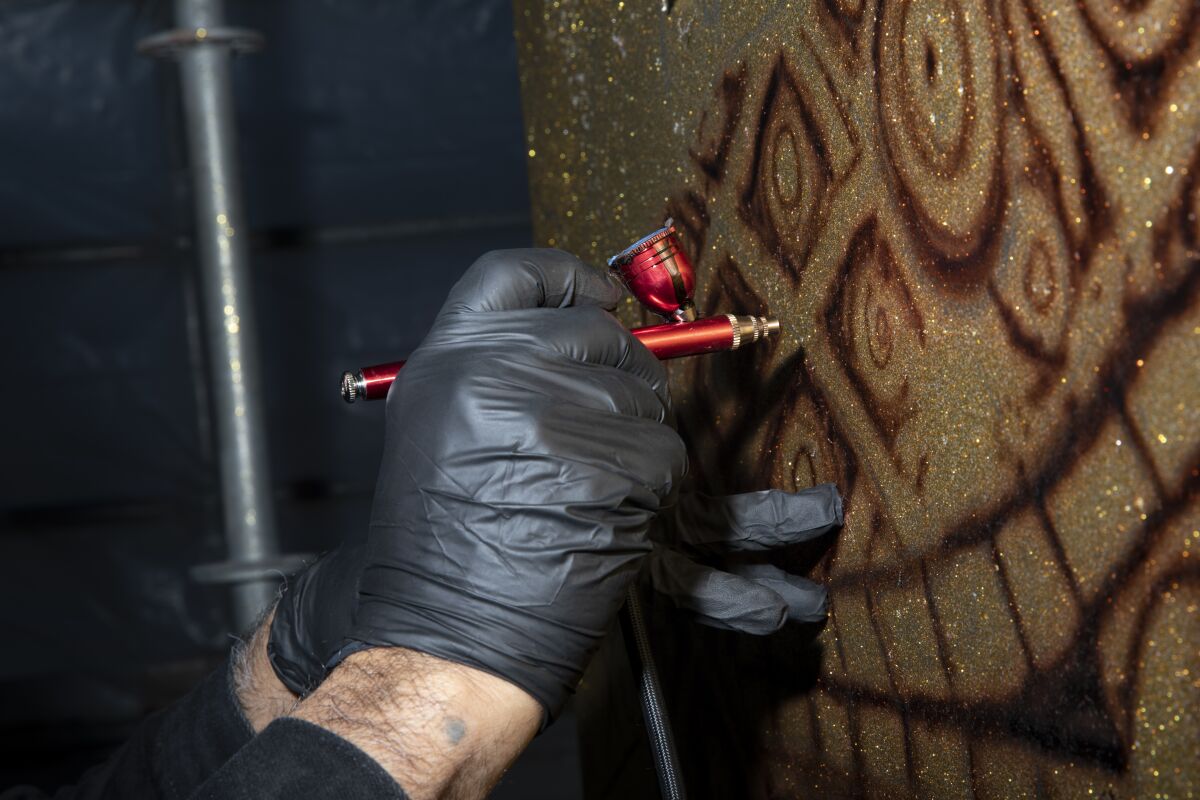 Roberto R. Pozos, 60, helps paint a five-story mural called "Brown Image" on a pillar in Chicano Park.