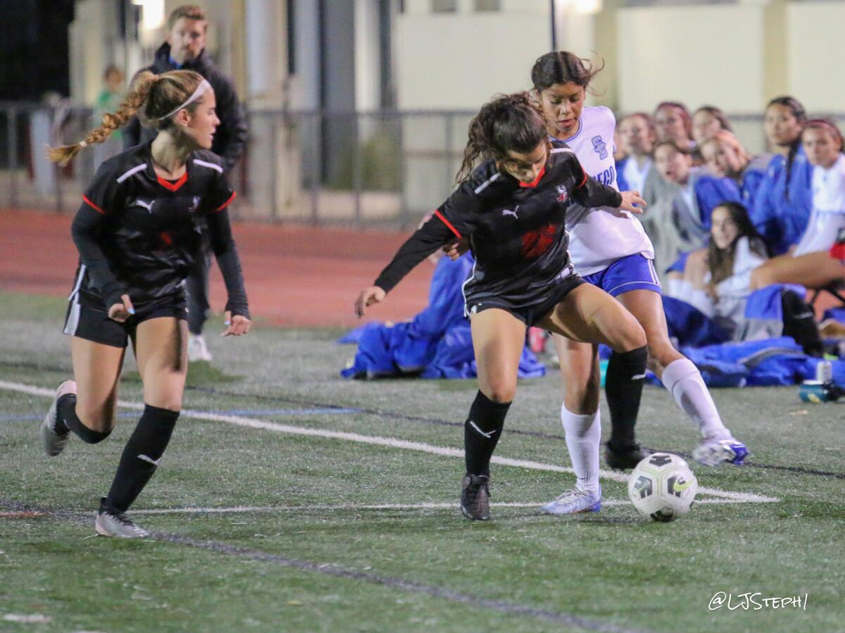 La Jolla High School Vikings (in black) work together to maintain possession of the ball during a recent soccer game.
