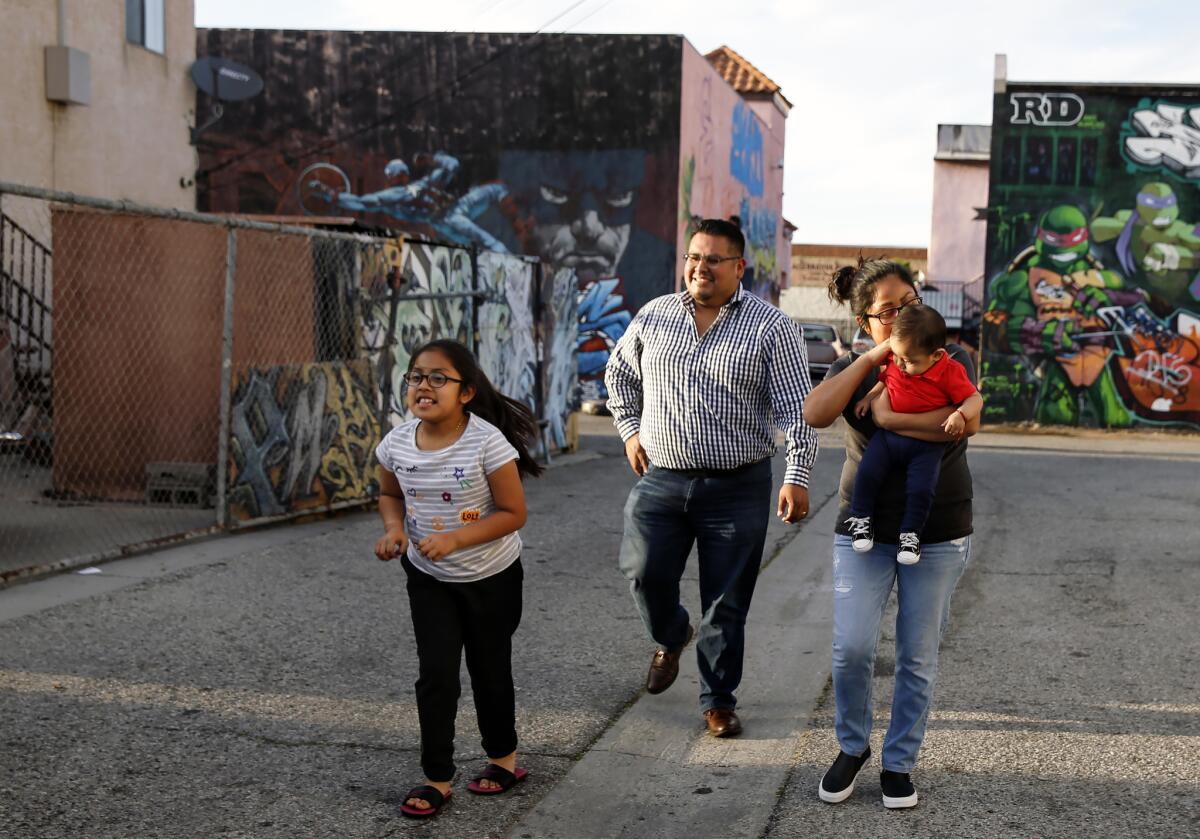 Irie walks with her dad, Miguel Mazas, mom, Miriam Bautista, and brother, Carlos, near their L.A. home. (Dania Maxwell / Los Angeles Times)