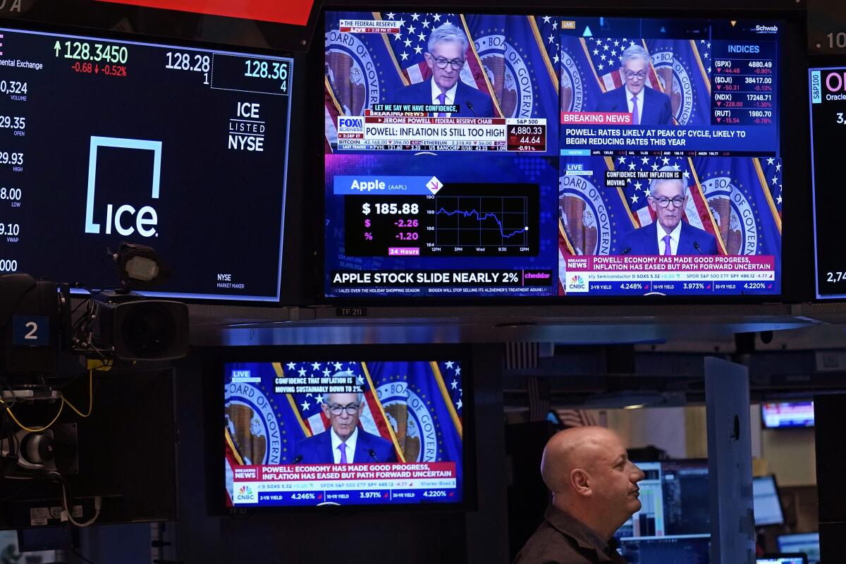 TV screens show Fed Chair Jerome Powell speaking