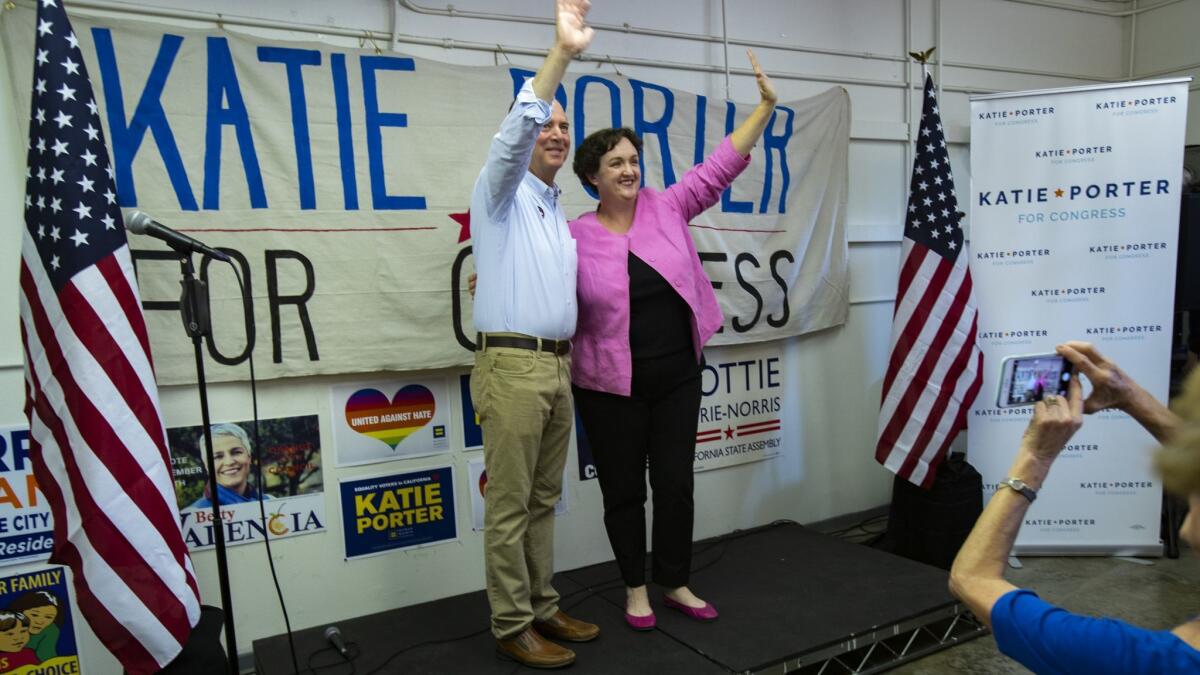Rep. Adam Schiff of Burbank and Democratic House candidate Katie Porter wave to the crowd during a rally at her Tustin campaign headquarters on Tuesday.