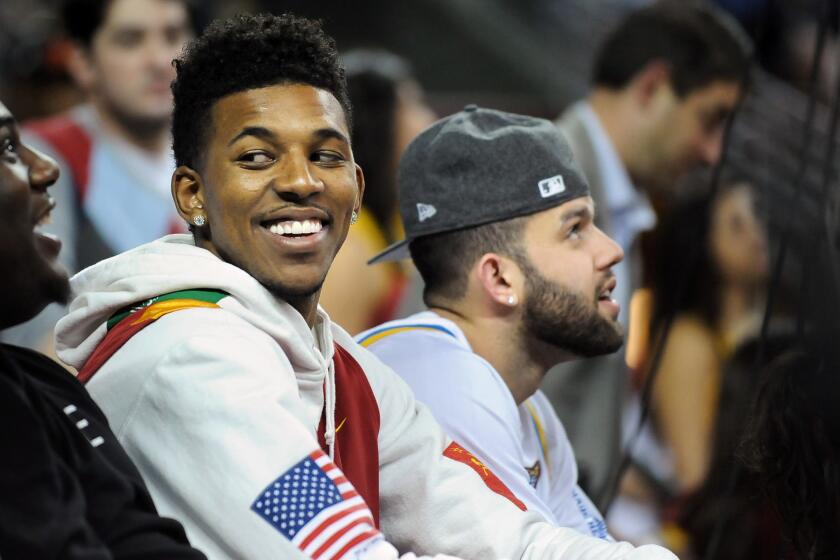 Lakers teammates Nick Young, left, and Jordan Farmar attend a USC-UCLA men's basketball game in February. They made more sporting rounds this week.