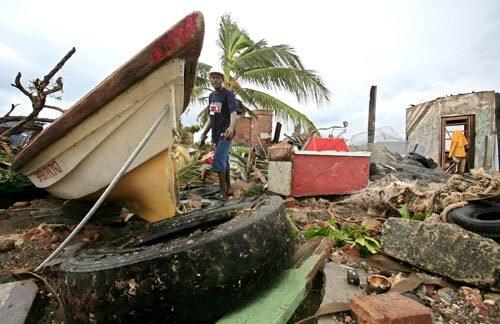 A fisherman surveys the damage to his boat after Hurricane Dean hit Kingston, Jamaica. The storm uprooted trees, flooded roads and left thousands of Jamaicans without electricity or telephone service.