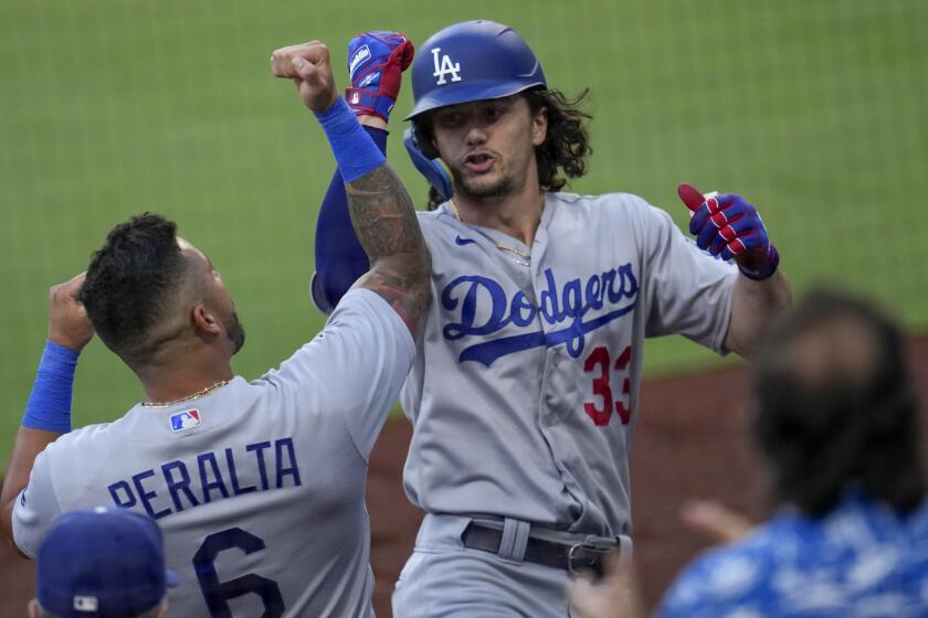 Los Angeles Dodgers' James Outman, right celebrates with teammate David Peralta after hitting a home run.