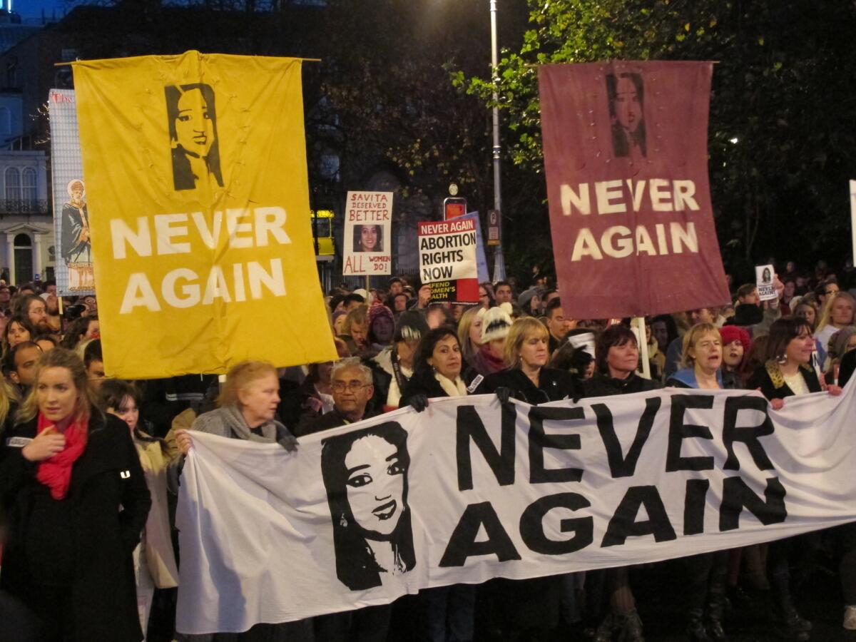 This file photo from Nov. 17 shows abortion rights protesters holding pictures of Savita Halappanavar as they march through Dublin, demanding Ireland's government ensures abortions can be performed to save a woman's life.