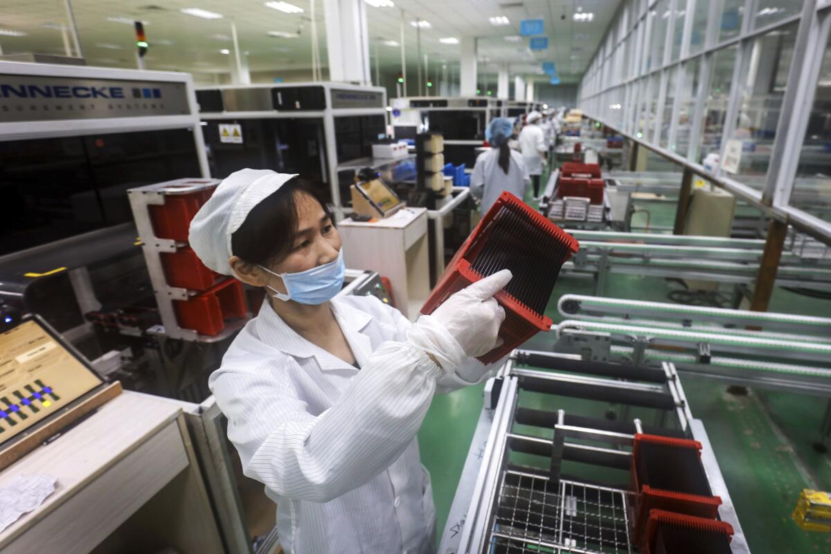 A worker checks solar panels at a Chinese factory. 