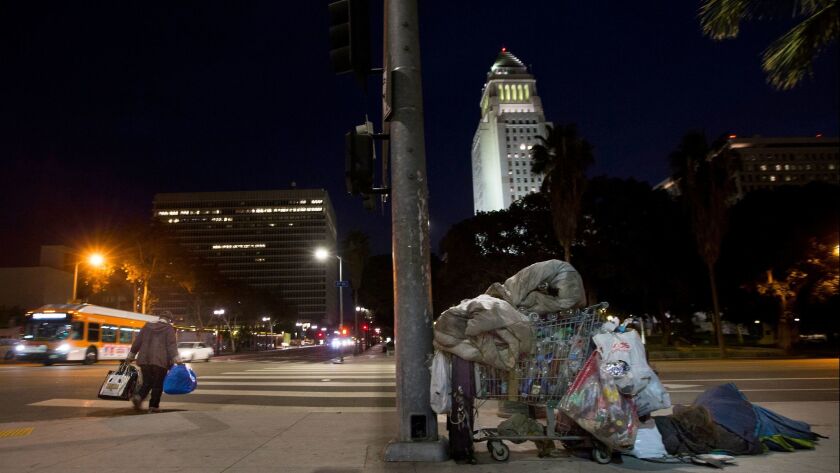 A person sleeps on the corner of First and Spring streets across from City Hall in downtown Los Angeles on Jan. 29.