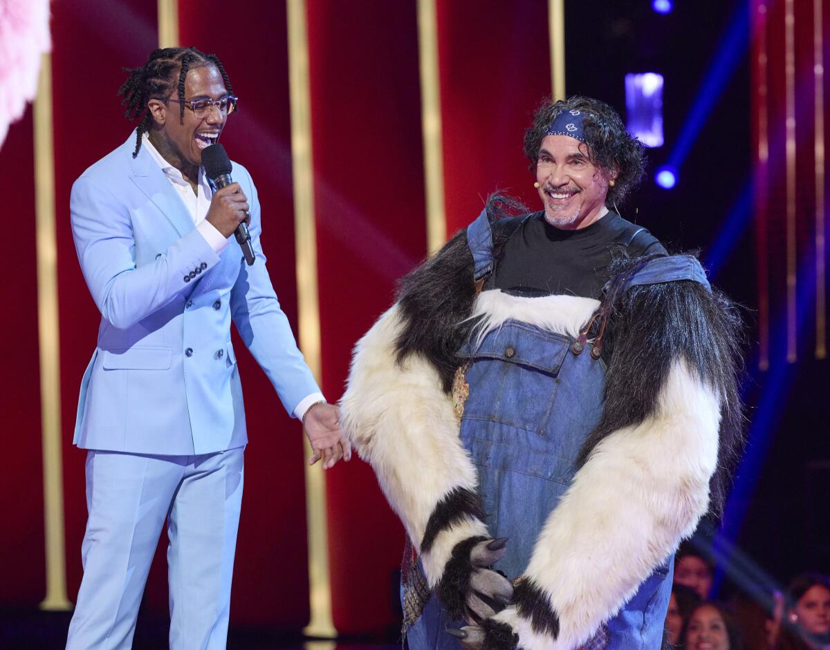 Nick Canon wears a baby blue suit and John Oates, right, wears blue overalls over a black and white fuzzy costume