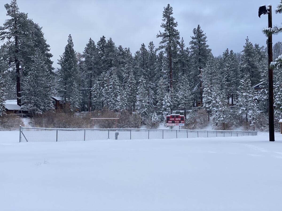 Big Bear scoreboard can be seen on a football field filled with snow.