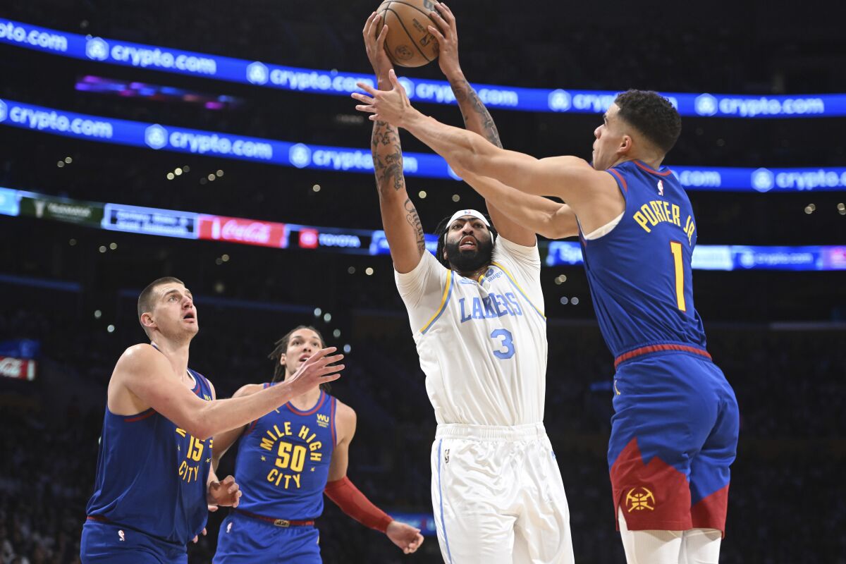 Lakers forward Anthony Davis grabs a rebound past Denver Nuggets forward Michael Porter Jr. during the first half.