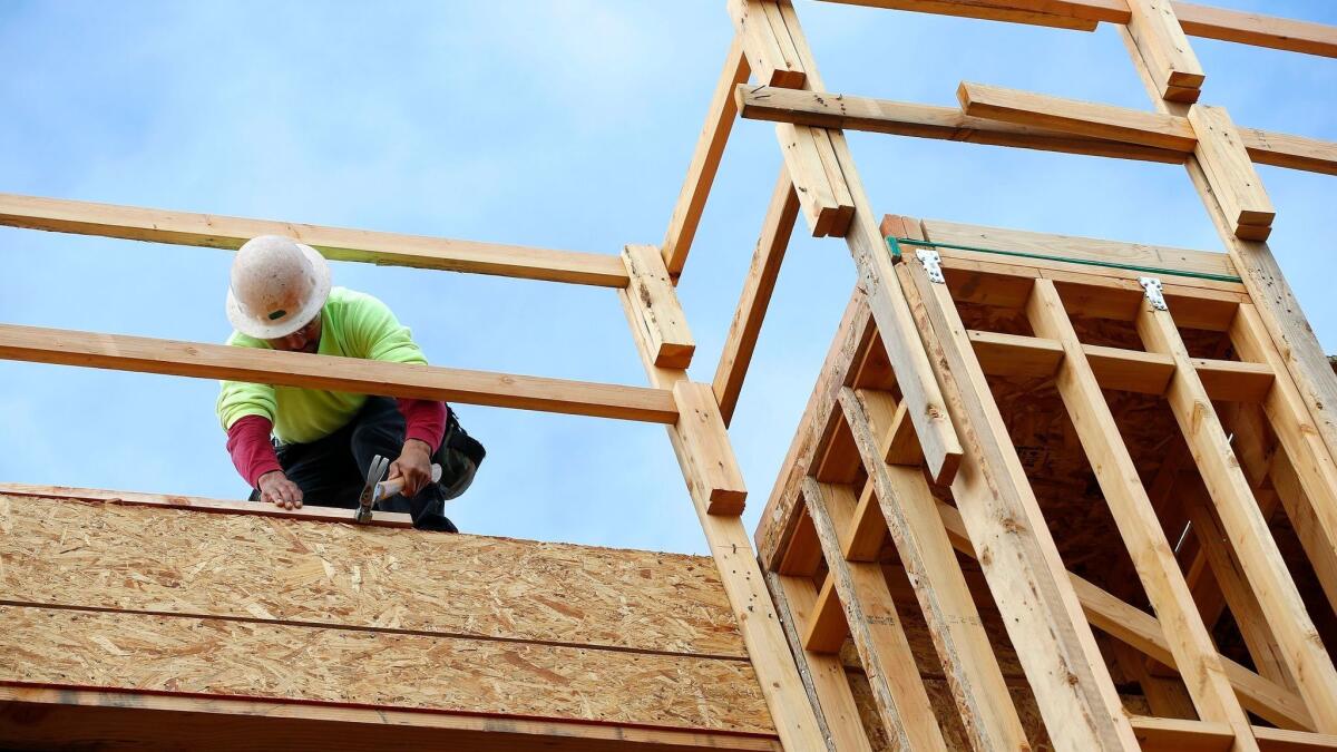 A builder works on a new apartment building under construction in Phoenix in January 2015.