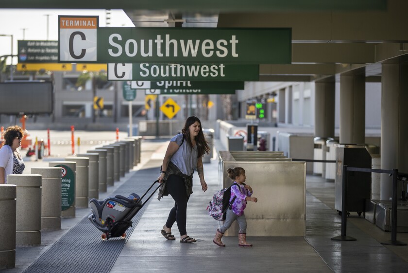 Travelers arrive at John Wayne Airport in Santa Ana