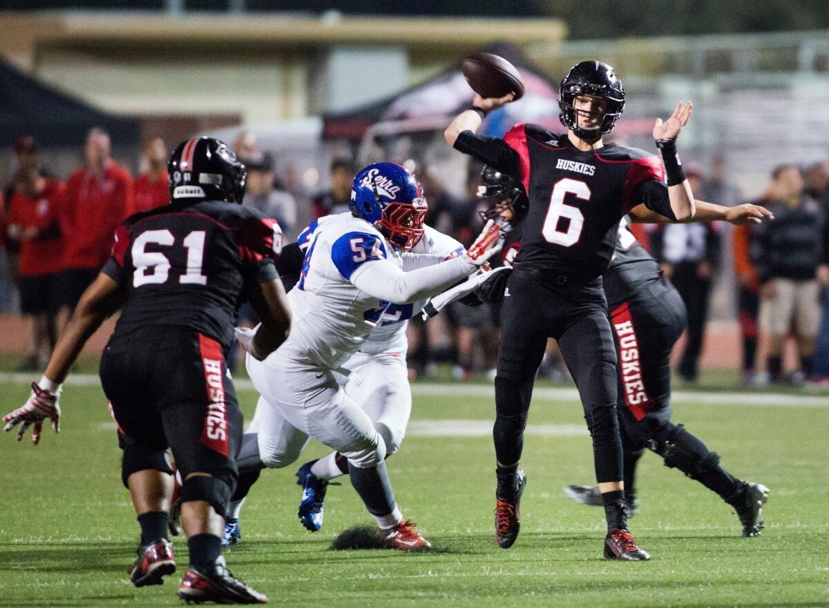 Corona Centennial quarterback Nate Ketteringham throws a pass deep down the field before taking a hit from Serra's Kordell Ross during a Pac-5 Division playoff game.