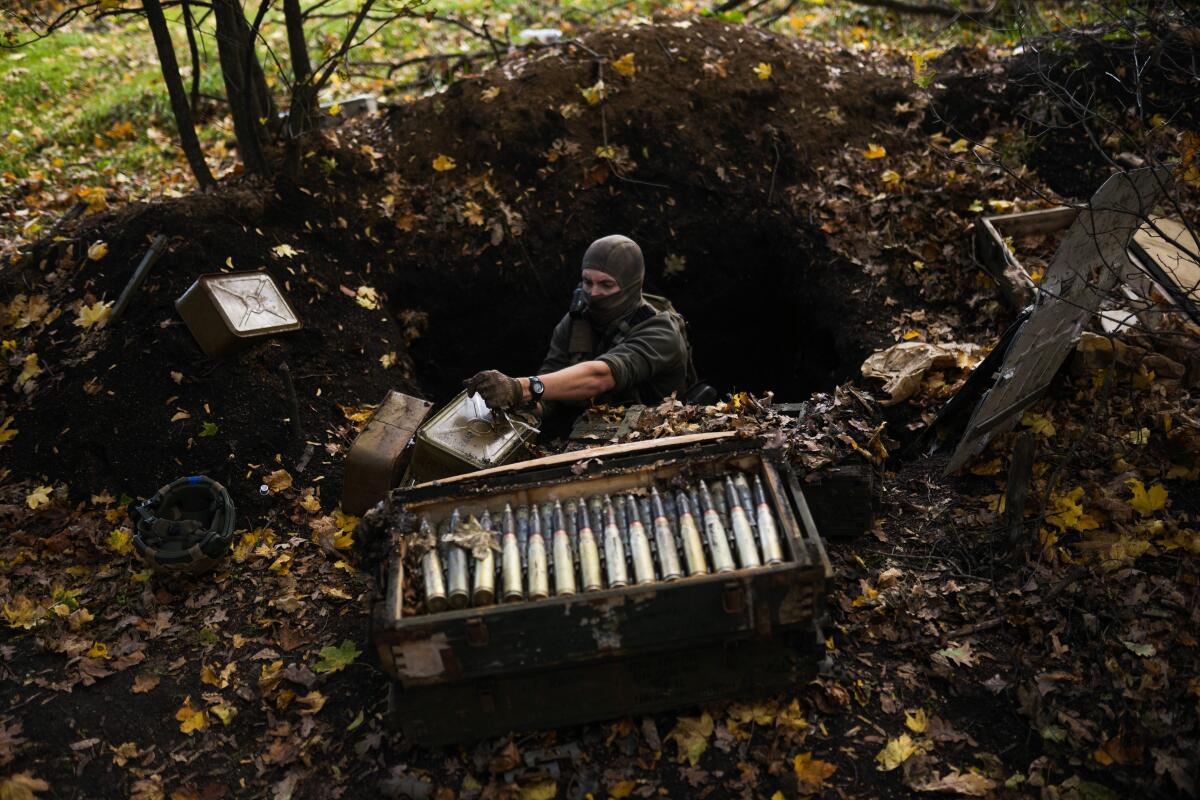 Un soldado ucraniano toma municiones que abandonaron las fuerzas rusas en su retirada 