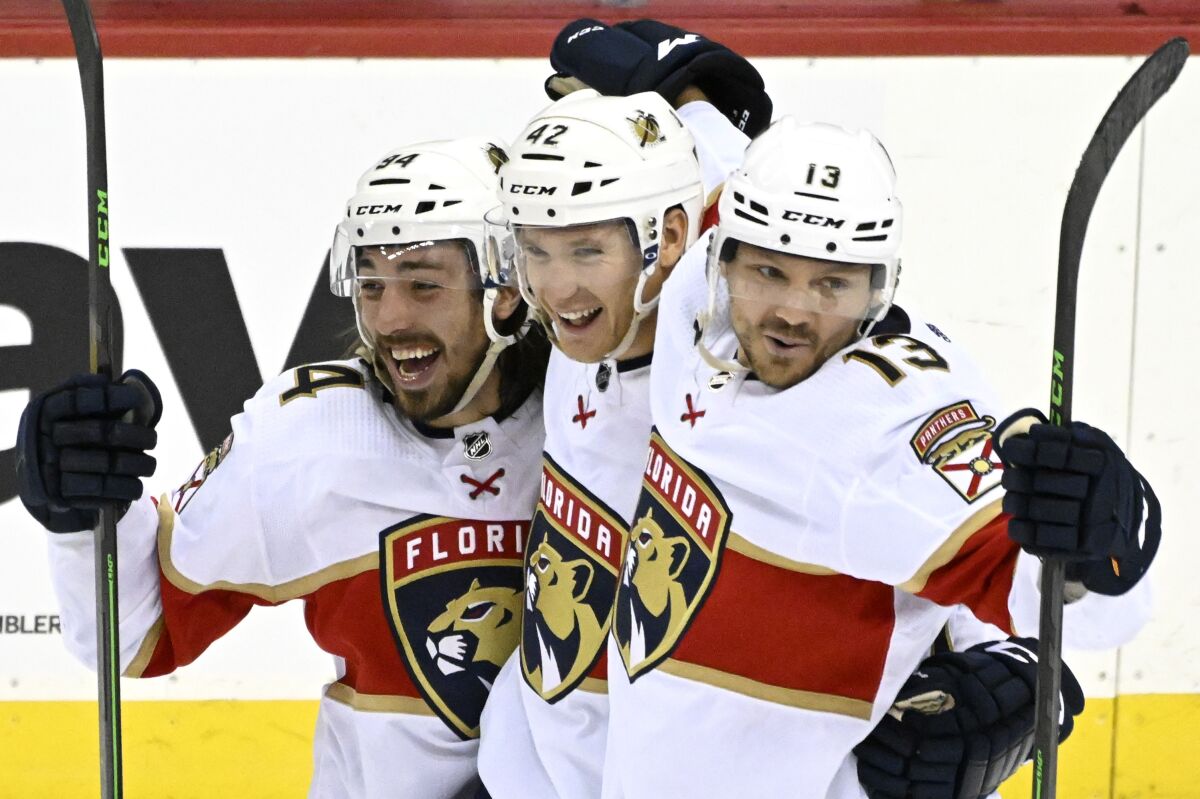 Florida Panthers defenseman Gustav Forsling (42) celebrates his goal with Ryan Lomberg (94) and Sam Reinhart (13) during the overtime period of an NHL hockey game against the New Jersey Devils Saturday, April 2, 2022, in Newark, N.J. The Panthers won 7-6 in overtime. (AP Photo/Bill Kostroun)