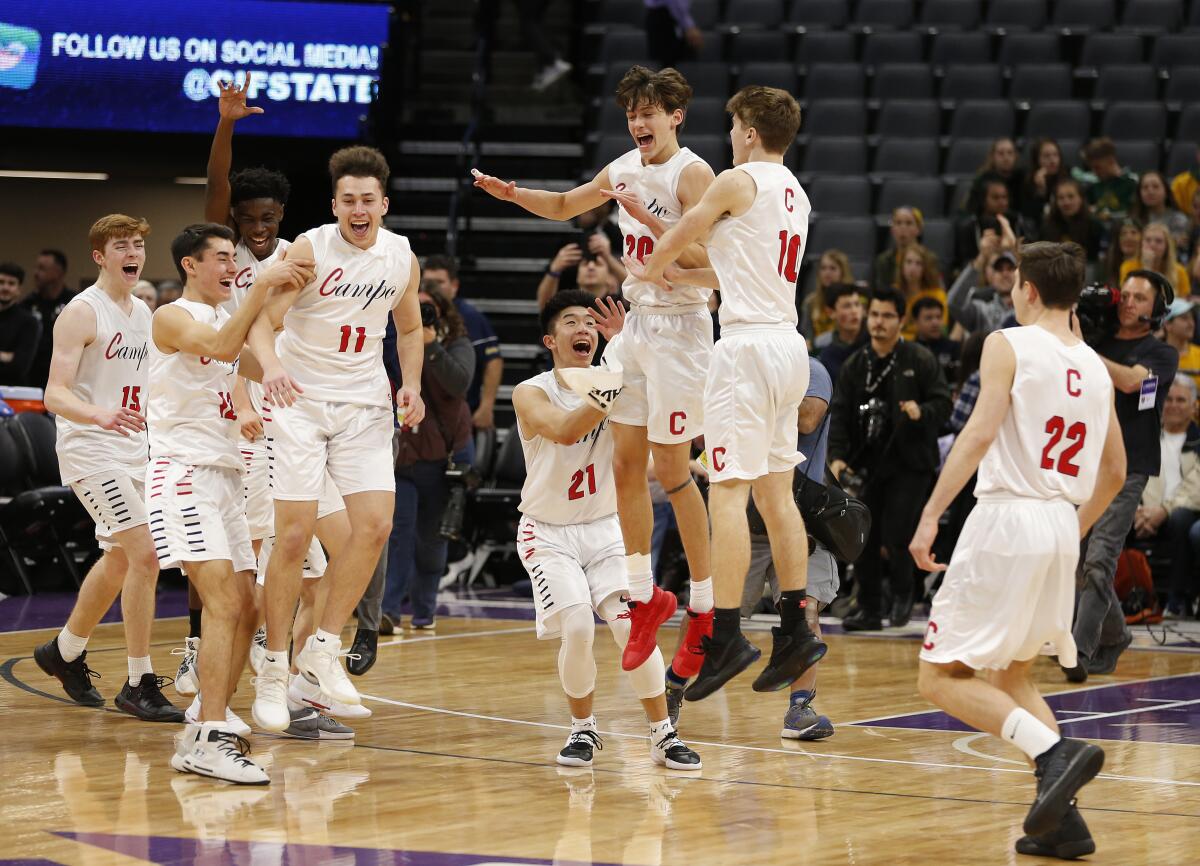 FILE - In this March 9, 2019, file photo, Campolindo players celebrate a win over Colony in the CIF boys' Division II state high school basketball championship game in Sacramento, Calif. On Thursday, March 4, 2021, lawyers representing two high school athletes say Gov. Gavin Newsom's administration has agreed to allow all indoor youth sports to resume as part of a lawsuit settlement. (AP Photo/Rich Pedroncelli, File)