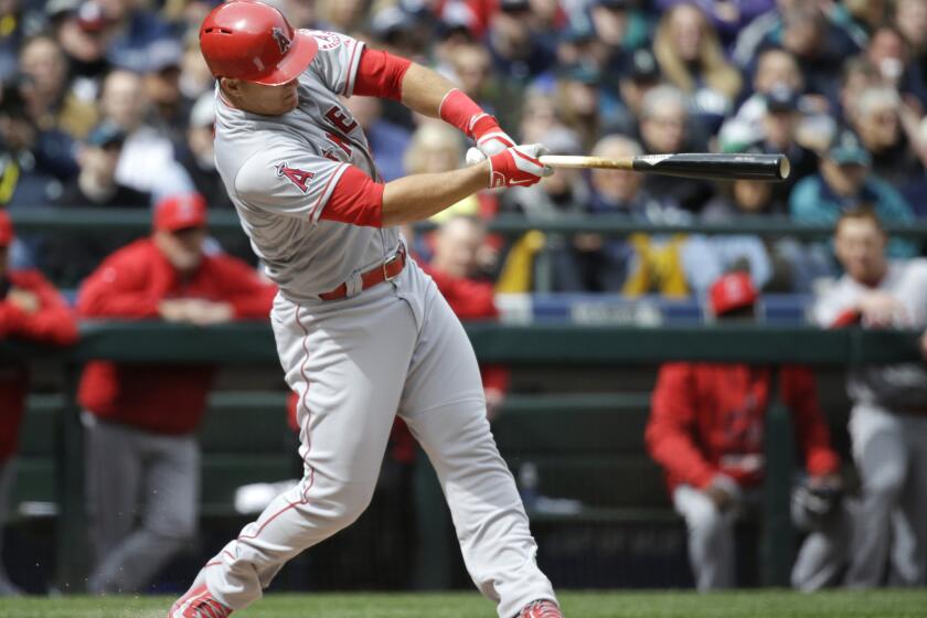 Mike Trout hits a home run in the first inning off of Seattle pitcher Felix Hernandez to give the Angels a 1-0 lead in their opening day game Monday against the Mariners.