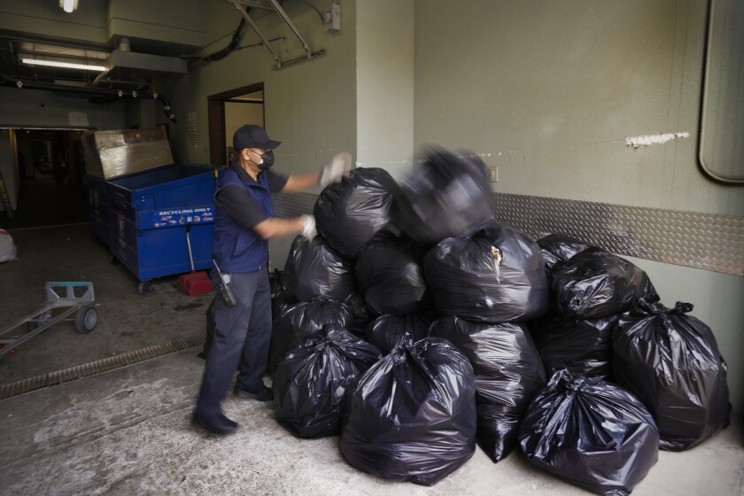 Marco Duarte, a maintenance worker at the Parkloft Condominiums, stacked more than a dozen full trash bags.