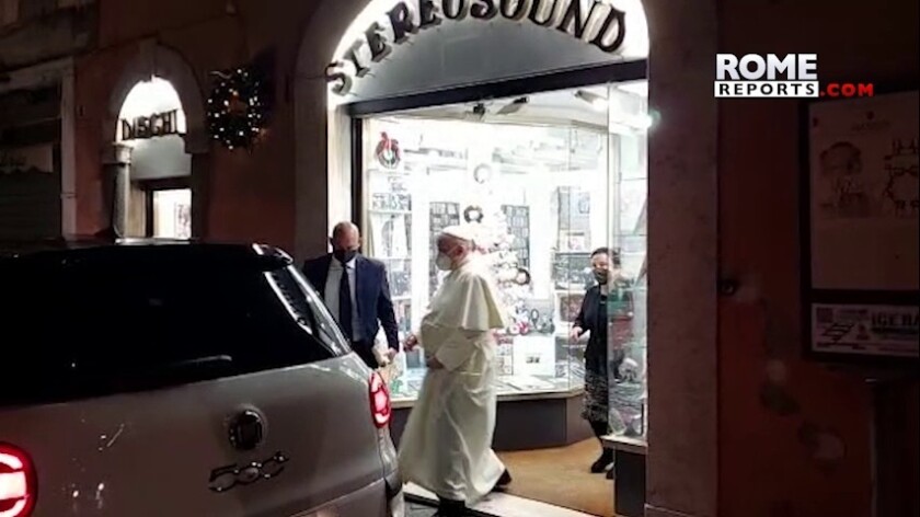In this image from video made available by Javier Martinez Brocal of Rome Reports, Pope Francis leaves a record shop in Rome, Tuesday, Jan. 11, 2022. Pope Francis grew up listening to the opera on the radio, is a fan of tango and milonga and thinks Mozart "lifts you to God." But it still came as a something of a shock to see him coming out of a downtown Rome record shop Tuesday evening with a CD in hand, after making an unannounced visit that was caught on camera by a Vatican reporter who happened to be nearby. (Javier Martinez Brocal/Rome Reports via AP)