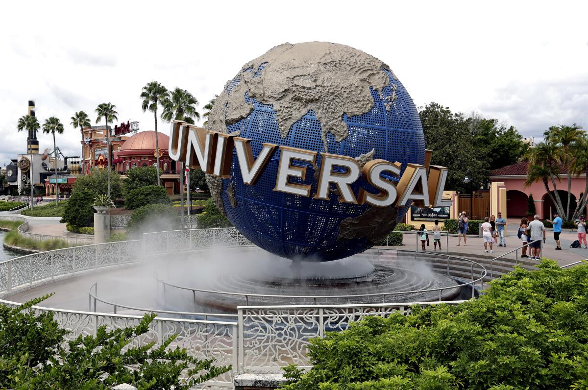 The giant, rotating Universal globe in a bed of fog surrounded by palm trees and other greenery