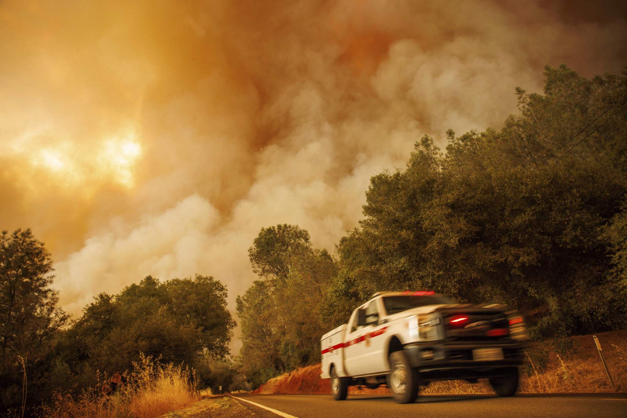 A firetruck passes as the Thompson fire burns in Oroville.