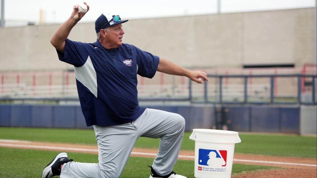 Mike Scioscia tosses balls to catchers Saturday at the Major League Baseball Youth Academy in Los Angeles. Scioscia is in his first year of retirement after a long run as manager of the Angels.