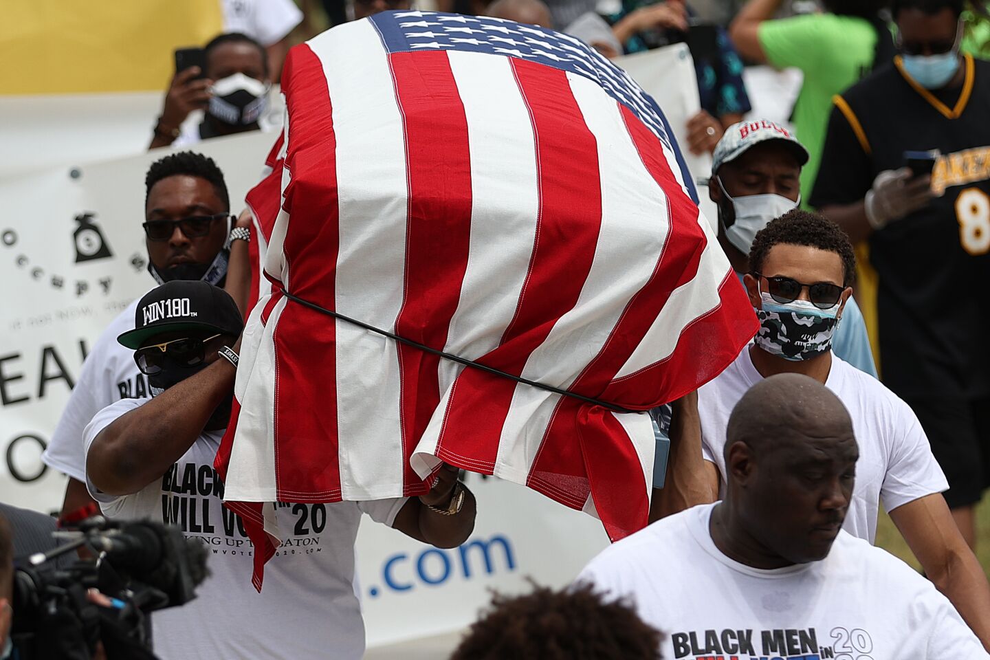 People carry a symbolic casket draped with an American flag during a Juneteenth event in the Greenwood District of Tulsa.