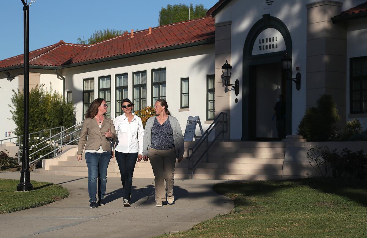 Kari Windes, Diane Stites and Mary Martinez, walk in front of Laurel Elementary.