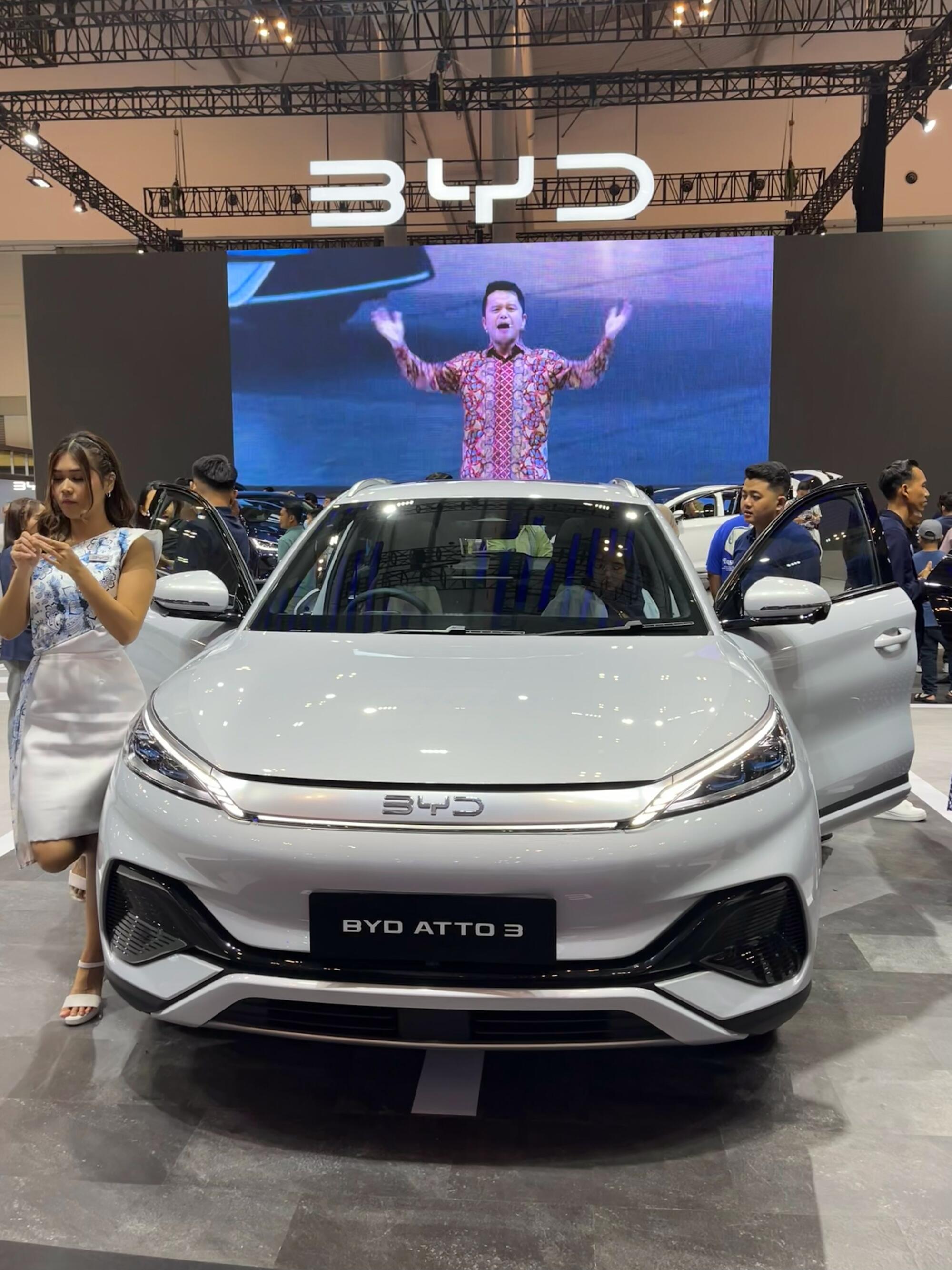 A BYD car on display with its front doors open at an auto expo