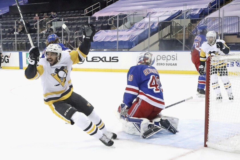 Pittsburgh Penguins' Pierre-Olivier Joseph celebrates the game winning goal by Sidney Crosby against New York Rangers' Alexandar Georgiev (40) in an NHL hockey game Saturday, Jan. 30, 2021, in New York. (Bruce Bennett/Pool Photo via AP)