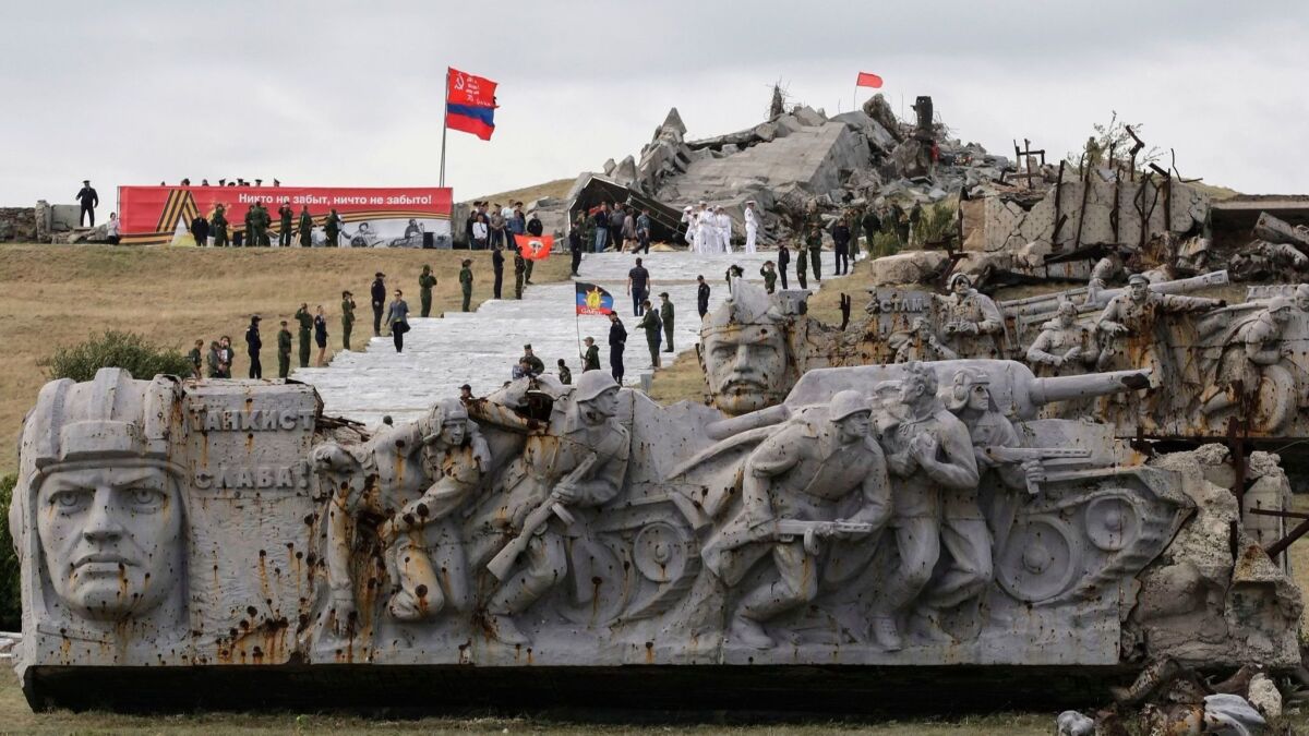 People visit the Savur-Mogila World War II Memorial, which was severely damaged during heavy fighting between the Ukrainian army and separatist rebels in territory controlled by the separatists near Snizhne, about 50 miles from Donetsk, Ukraine, on Sept. 7, 2018.