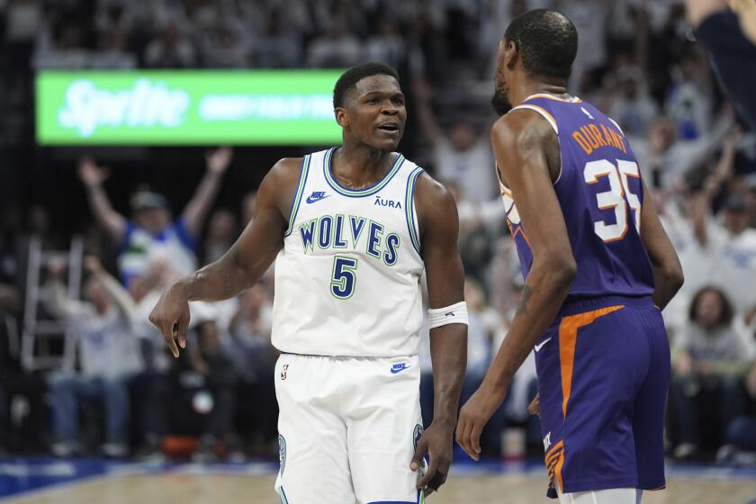 Minnesota Timberwolves guard Anthony Edwards (5) celebrates toward Phoenix Suns forward Kevin Durant (35) after making a 3-point shot during the second half of Game 1 of an NBA basketball first-round playoff series, Saturday, April 20, 2024, in Minneapolis. (AP Photo/Abbie Parr)