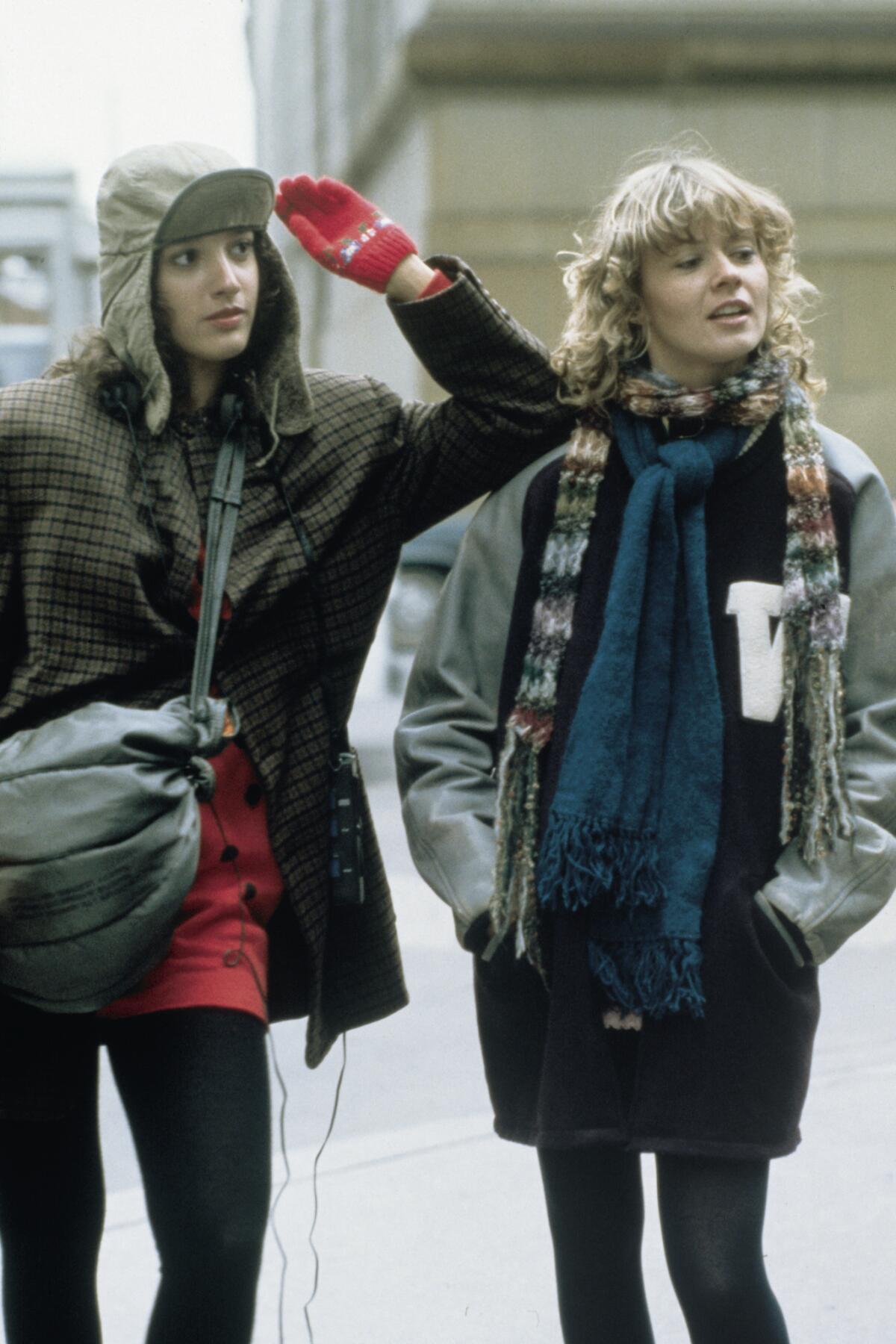 Two women in winter clothes walking on a street