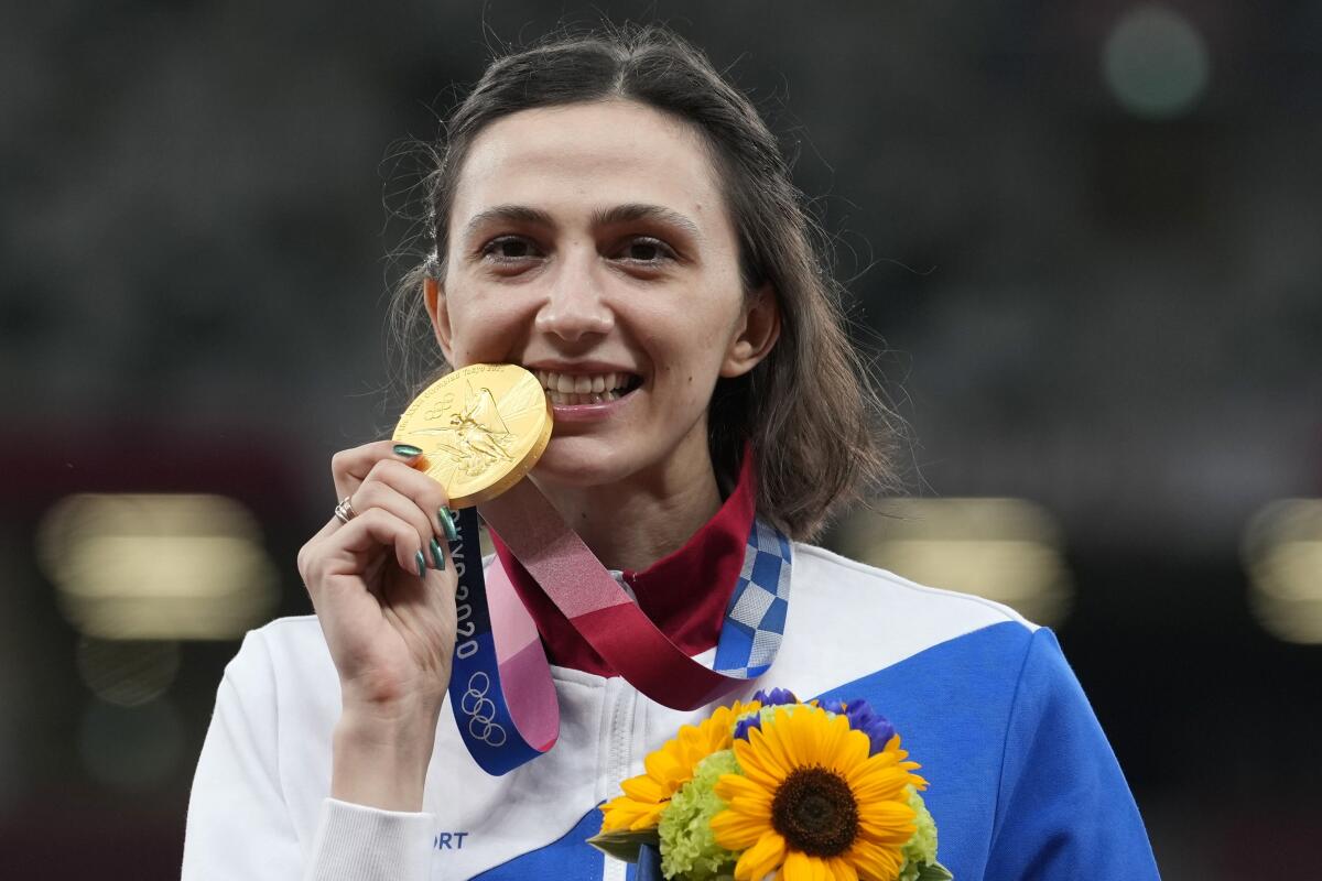 FILE - Gold medalist Mariya Lasitskene, of Russian Olympic Committee, celebrates during the medal ceremony for the women's high jump at the 2020 Summer Olympics, Aug. 7, 2021, in Tokyo. Olympic high jump champion Mariya Lasitskene is among 22 Russians given permission to compete in international track and field events as neutrals this year while Russia remains suspended. The decision by World Athletics comes in time for Lasitskene to defend her world indoor championship title next month. (AP Photo/Martin Meissner, file)