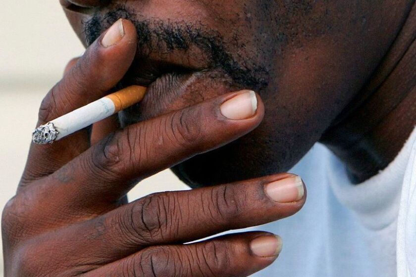FILE - In this Oct. 4, 2005 file photo, a man smokes a cigarette in Euharlee, Ga. According to a report by the American Cancer Society released on Thursday, Feb. 14, 2019, cancer deaths have dropped for all Americans, but the rates have fallen faster in blacks than whites. Experts say the main reason is that smoking rates fell more dramatically in blacks in the past 40 years, and that’s paying off in fewer deaths now. (AP Photo/Ric Feld)