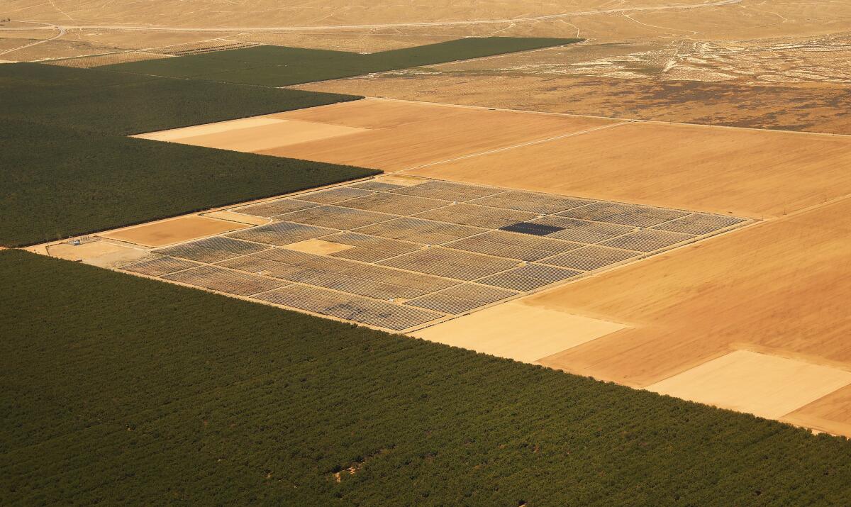 An aerial view of land with tan, brown and green acreage.