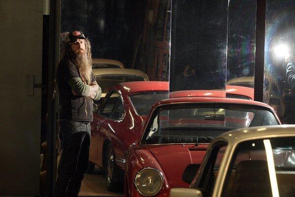 Magnus Walker is reflected in a mirror by the side of his 1965 Porsche 911 inside his downtown Los Angeles arts district warehouse. For more than a decade, Walker has transformed scrap heaps into one-off custom 911s, earning him the nickname "Urban Outlaw."