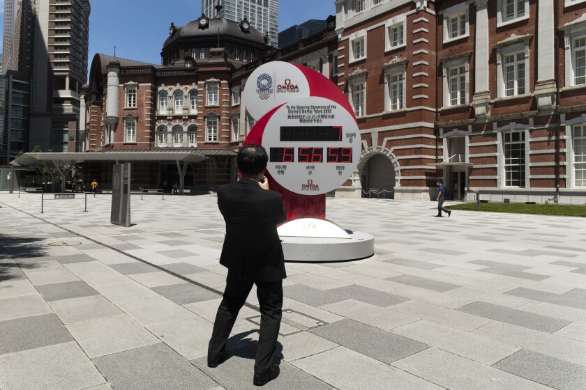 A man takes a picture of a countdown clock that shows seven more days to go before the opening ceremony of the Tokyo Olympic Games in Tokyo Friday, July 16, 2021. (AP Photo/Hiro Komae)