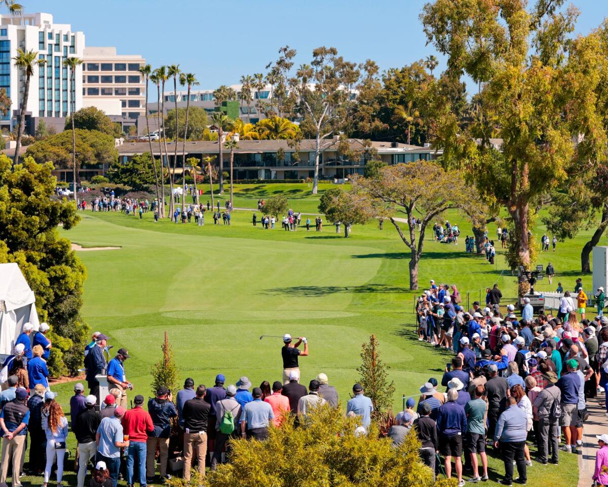Fans view the Hoag Classic gather on the greens in the shadow of Fashion Island.
