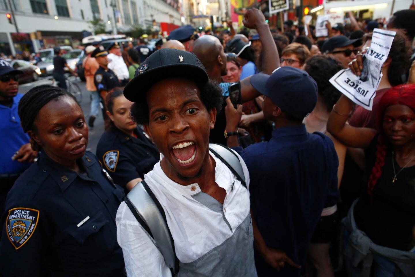 People take part in a march in reaction to the acquittal of George Zimmerman in New York July 14, 2013. Thousands of protesters chanting "No justice, no peace" gathered in New York City on Sunday to protest the acquittal of George Zimmerman in the shooting death of unarmed black teenager Trayvon Martin, which prompted rallies across the country.